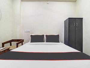 a bedroom with a large bed and a cabinet at HOTEL PNR SUITES KUKATPALLY in Hyderabad