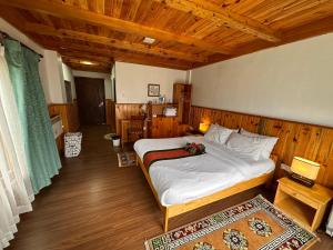 a bedroom with a bed and a wooden ceiling at Jambayang Resort in Thimphu