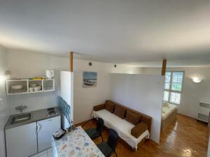 a small room with a couch and a table in it at Apartment Bugenvila in Vrboska