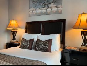 a bedroom with a bed with pillows and two lamps at Spacious-Cozy 2Bed Condo in Square Ones Misissauga in Mississauga