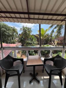 a patio with two chairs and a table on a balcony at Sportsman beach hotel in Calangute