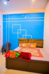a bedroom with a large bed with a blue wall at Shri ram doot niwas in Ayodhya
