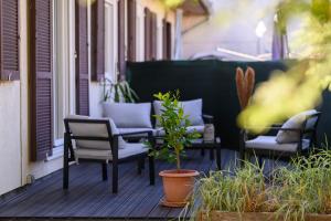 a porch with chairs and a potted plant at Le Bohème par Vosges Sérénité in Épinal