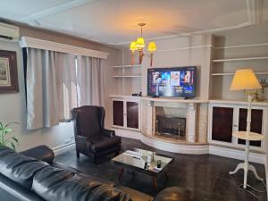 a living room with a couch and a tv at Cobertura duplex Landmark jardins in São Paulo