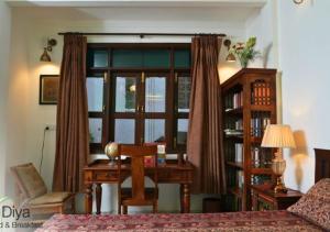 a room with a desk and a table and a window at Diya Bed and Breakfast in New Delhi