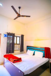 a bedroom with a white bed with a ceiling fan at Shri ram doot niwas in Ayodhya