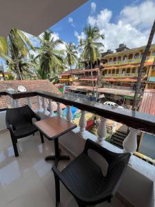 a balcony with chairs and a table and a view of a building at Sportsman beach hotel in Calangute