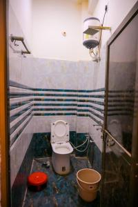a small bathroom with a toilet and a shower at Shri ram doot niwas in Ayodhya