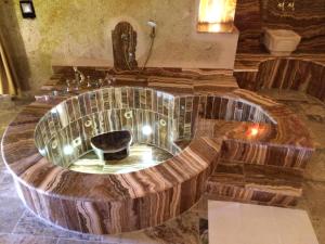 una gran bañera de madera en una habitación con lavabo en Oread Cave Suites, en Ürgüp