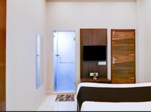 a room with a blue door and a television at Hotel Rose Inn in Kolkata