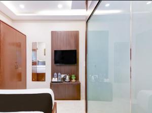a room with a bed and a television in a room at Hotel Rose Inn in Kolkata +12 photos