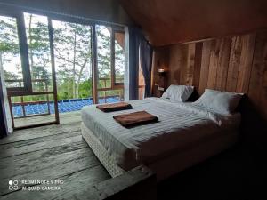 a bedroom with a bed and a large window at Wana Wooden House in Munduk