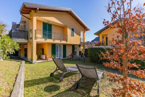 a house with chairs and a tree in the yard at giardino e piscina apartment in Bellagio