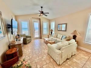 a living room with couches and a flat screen tv at Skinny Mini-Beachfront-3BR in St. George Island
