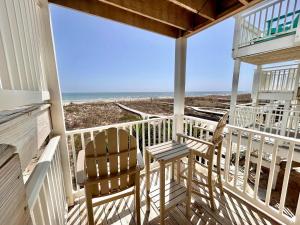 a porch with two chairs and a view of the beach at Skinny Mini-Beachfront-3BR in St. George Island
