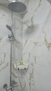 a shower in a bathroom with white marble walls at Vedo apartment 3 Тячів in Tyachiv +13 photos
