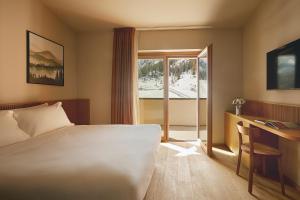 a hotel room with a bed and a desk and a window at Rifugio Colere 1600 by Cloud 7 in Colere +42 photos
