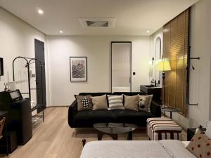a living room with a black couch and a table at The Atelier House in Krabi