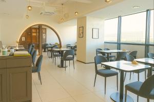 a dining room with tables and chairs and windows at 부산 엘스테이 호텔 레지던스 EL STAY Busan Long Stay Hotel Residence l 아르떼20 OFF짚라인30 OFF스릴10 OFF 할인 in Busan