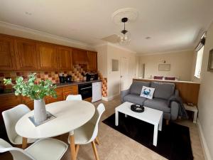 a kitchen and living room with a table and a couch at Seagulls Rest - Sheringham in Sheringham