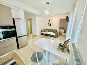 a kitchen and living room with a white table and chairs at Iulius Mall New Residence in Iaşi