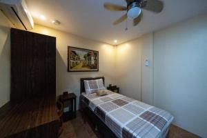 a bedroom with a bed and a ceiling fan at Coba Inn Alona Panglao in Panglao Island