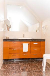 ein Badezimmer mit einem Waschbecken und einem großen Spiegel in der Unterkunft Ringhotel Teutoburger Wald in Tecklenburg