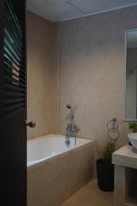 a bathroom with a bath tub and a sink at Base 22 Hatyai in Ban Rai