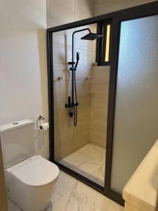 a bathroom with a shower and a toilet with a glass door at Luxueux duplex 2-bedroom in Ashalebotwe +18 photos