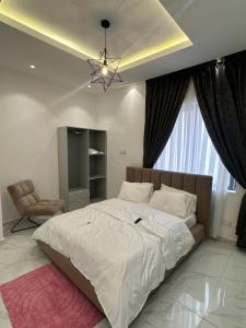 a bedroom with a large white bed and a chandelier at Luxueux duplex 2-bedroom in Ashalebotwe