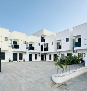 a large white building with trees in the courtyard at Luxueux duplex 2-bedroom in Ashalebotwe