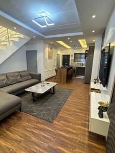 a living room with a couch and a table at Luxueux duplex 2-bedroom in Ashalebotwe