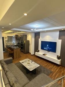 a living room with a couch and a flat screen tv at Luxueux duplex 2-bedroom in Ashalebotwe