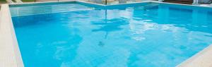 a large swimming pool with blue water at PROSERPINE MOTOR LODGE in Proserpine