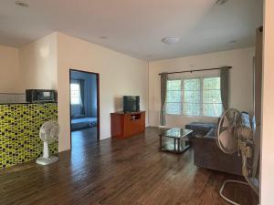 a living room with a couch and a fan at baan wongsupar in Suan Phung