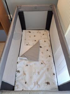 a small bed in a box with a blanket at Victoria Wave Apartman in Balatonőszöd
