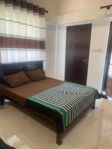 a bedroom with a bed with a striped comforter at Sedna hotel in Mahawewa