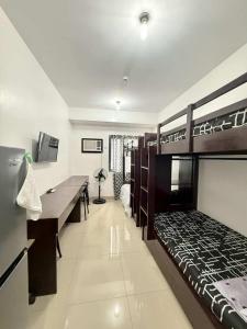 a bedroom with two bunk beds and a desk at Blanc Suite in Pasong Bayog