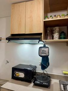 a kitchen counter with a microwave and a toaster oven at Blanc Suite in Pasong Bayog