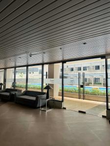 a lobby with couches in a building with windows at Blanc Suite in Pasong Bayog