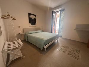 a bedroom with a bed and a chair and a window at ModicAlta in Modica