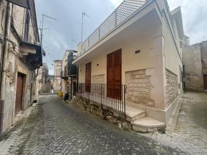 an alley with a building with a gate on a street at ModicAlta in Modica