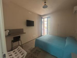 a bedroom with a bed and a television and a chair at ModicAlta in Modica