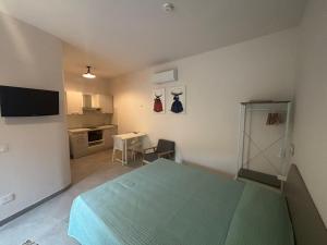 a bedroom with a green bed and a kitchen at ModicAlta in Modica