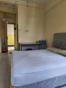 a bedroom with a large white bed in a room at Comfy Studio Emerald Hills in Telukjambe +5 photos