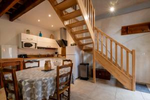 a kitchen and dining room with a table and a staircase at Gîte Léon - Au cœur du village 4 pers in Gargilesse-Dampierre