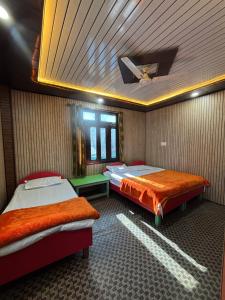 a bedroom with two beds and a ceiling at Gauri Homestay in Pithorāgarh