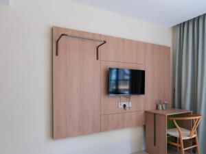 a room with a tv on a wall with a table at Green Hotel in Puchong +16 photos