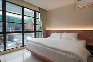 a bedroom with a large bed and a large window at Green Hotel in Puchong