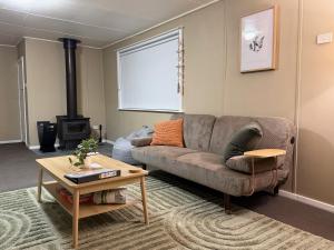 a living room with a couch and a wood stove at Kangaroo Cottage in Hay